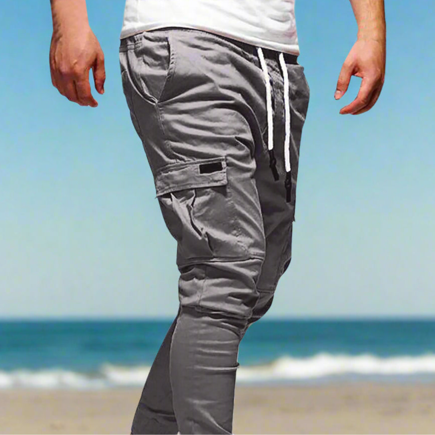 Gray jogger pants with multiple pockets and a drawstring on a white background